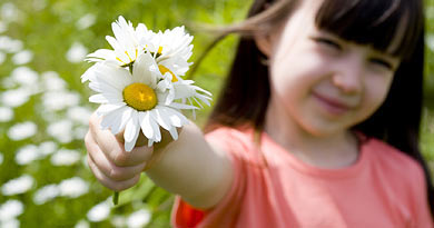 Foto: Kind mit Margerite in der Hand